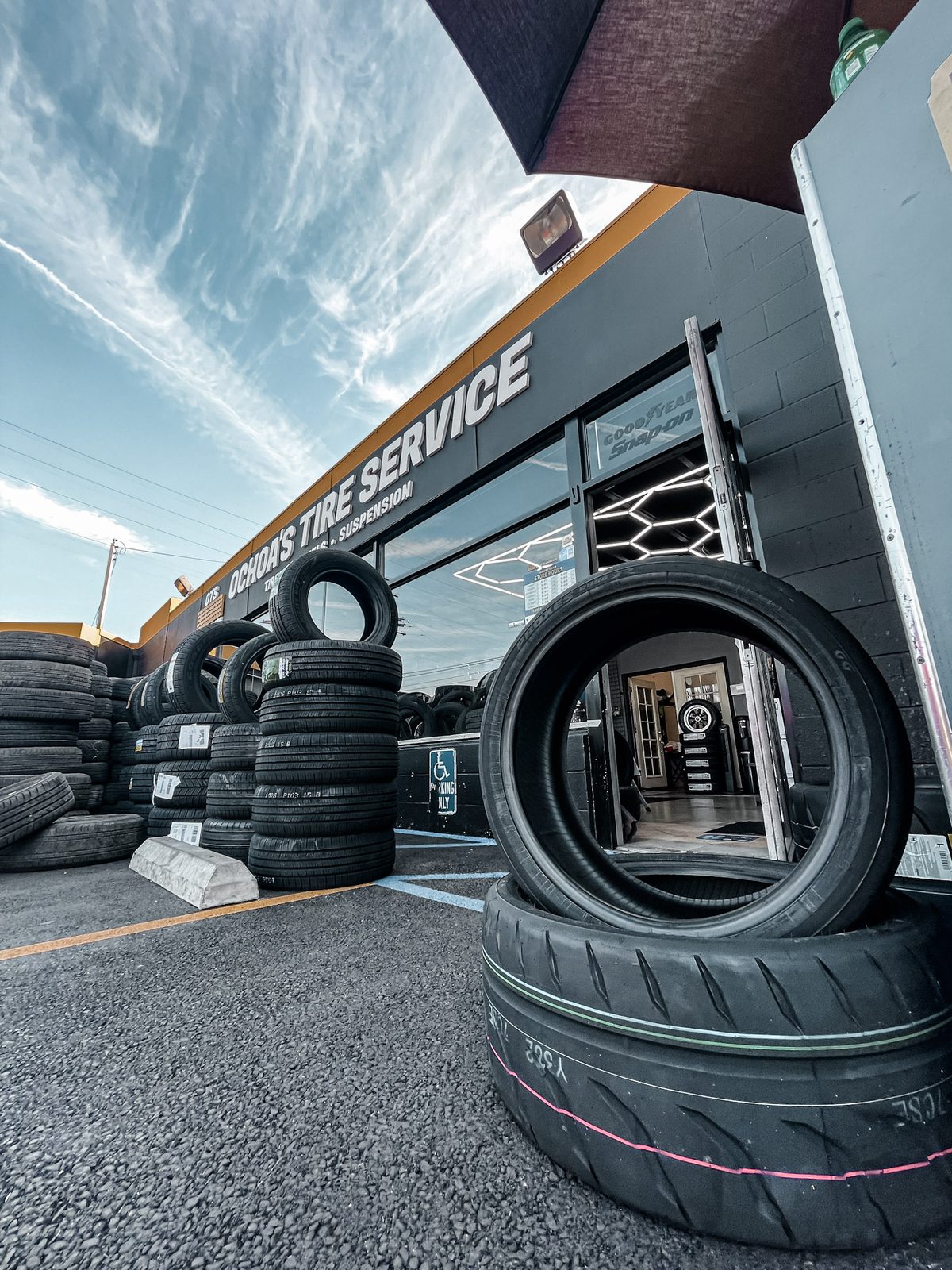 Tires stacked outside Ochoa's Tire Service on Cherry Ave, with the OTS storefront sign in the background