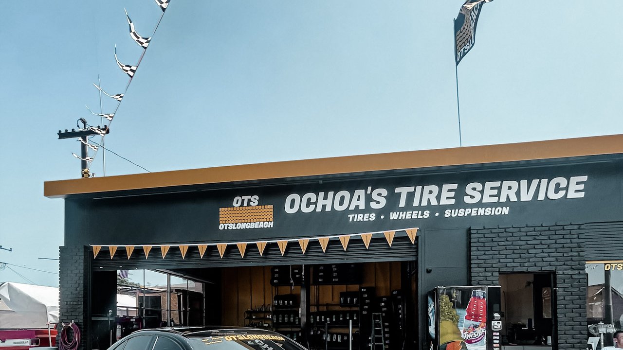 Ochoa's Tire Service Paramount Blvd — yellow OTS signage, open service bays with tires and wheels visible inside